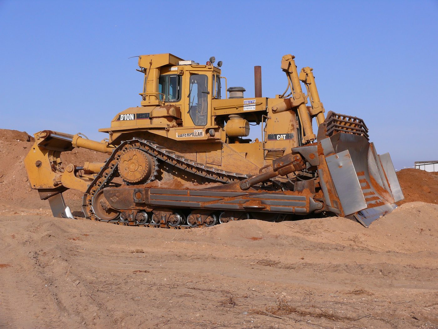 Yellow bulldozer on sandy ground