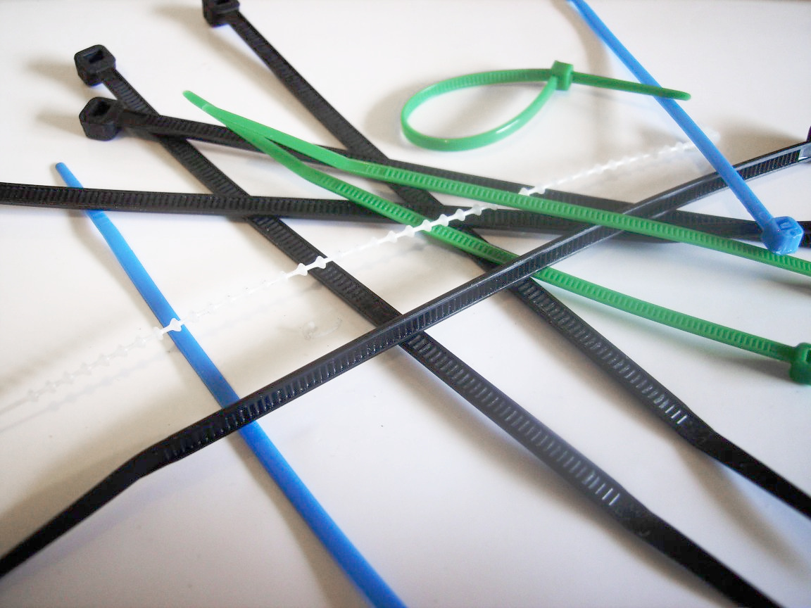 Various colored cable ties on white surface
