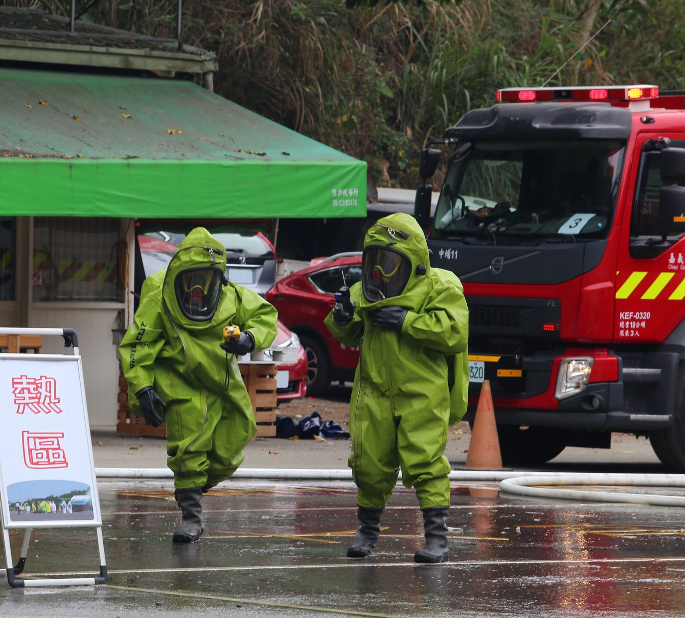 Two people wearing chemical splash suits