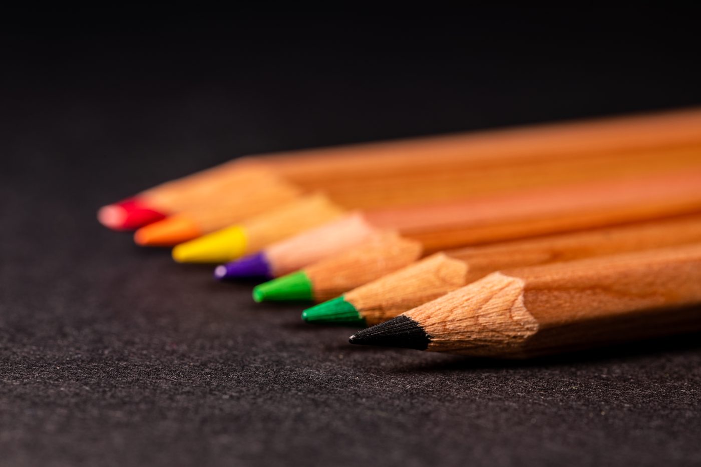 Colored pencils arranged on a dark surface