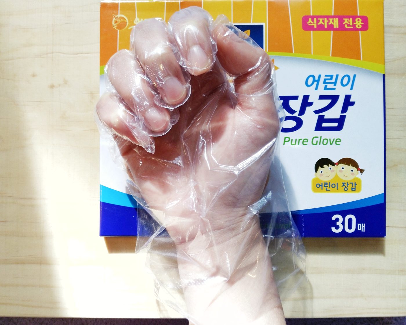 Hand wearing a clear disposable glove
