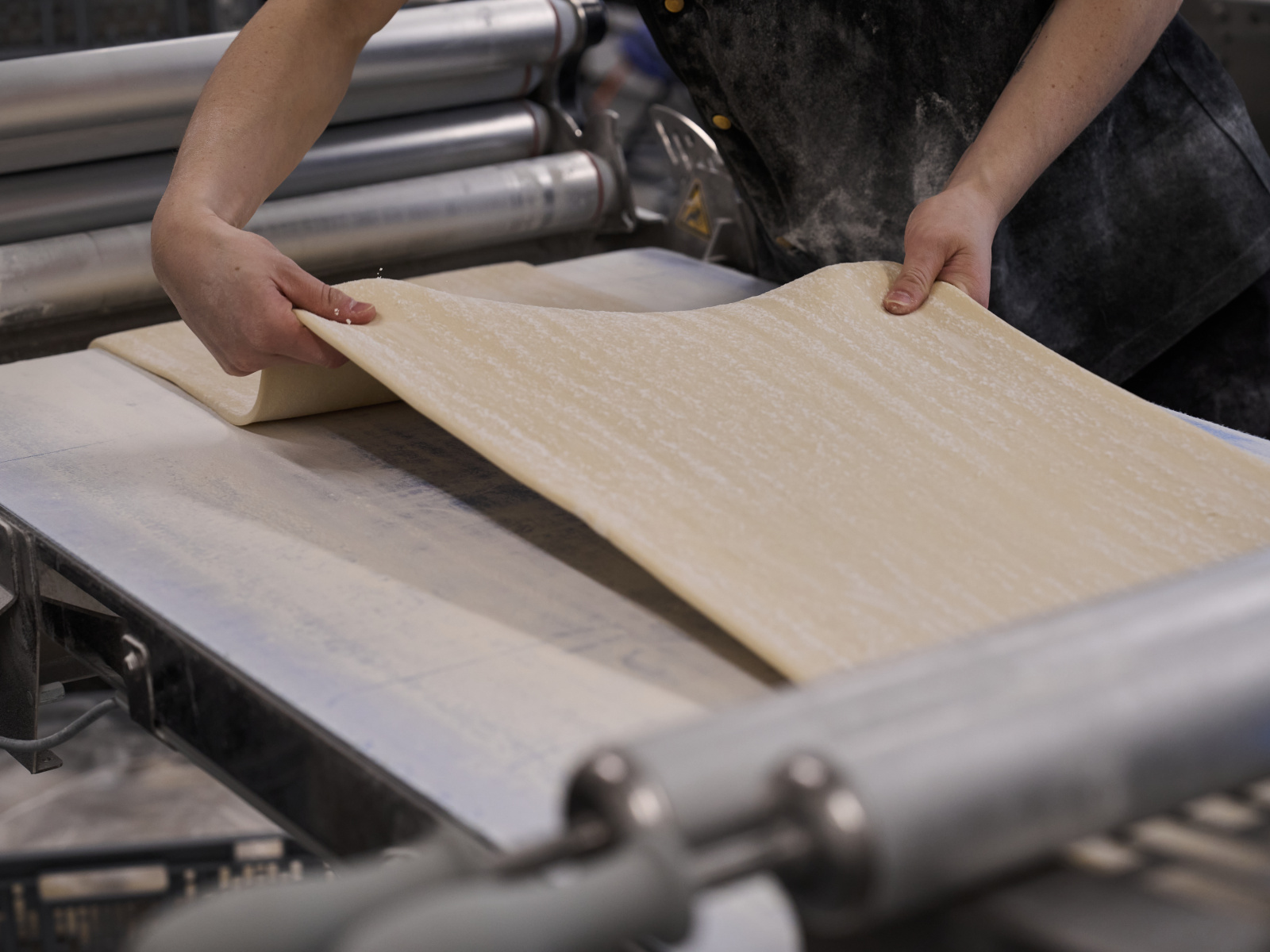 Dough being processed on a dough sheeter