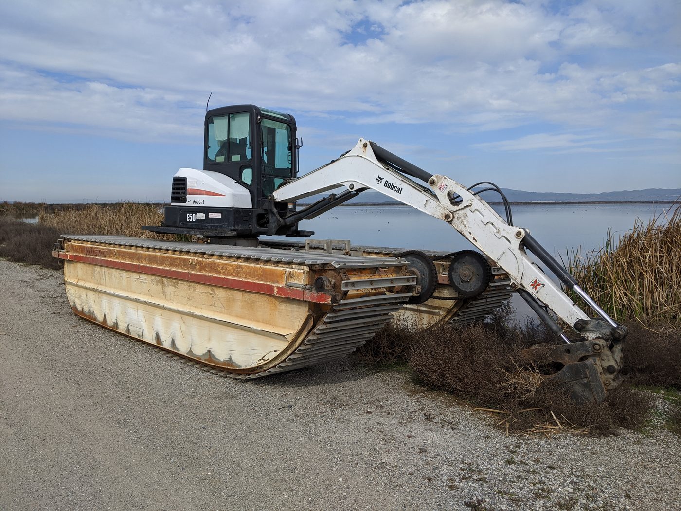 Amphibious excavator at work near water
