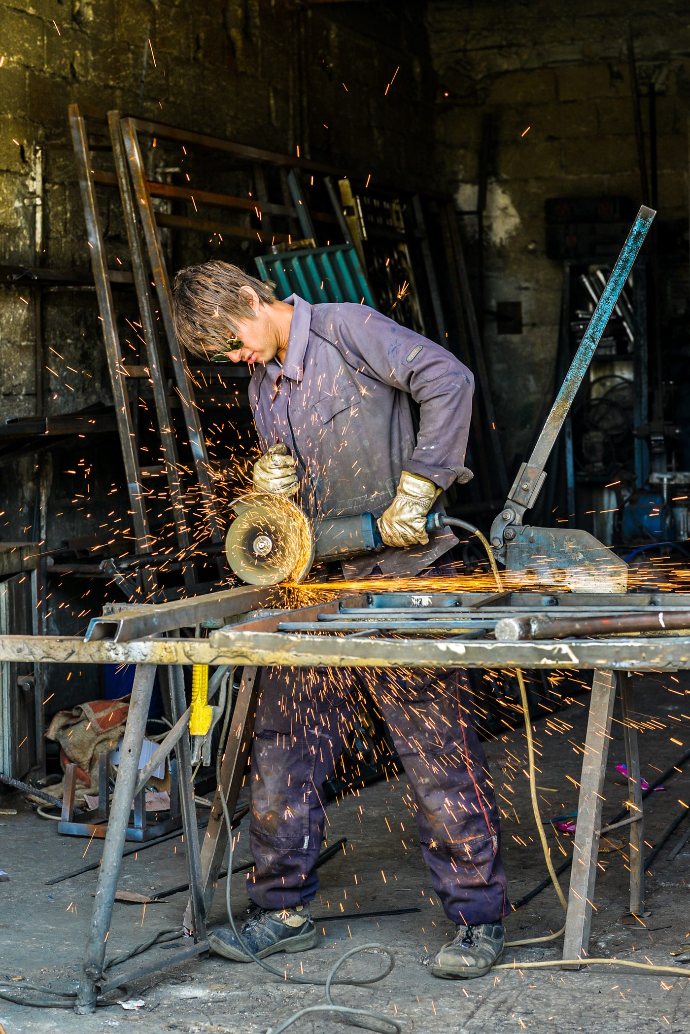 Worker wearing hand gloves using grinder