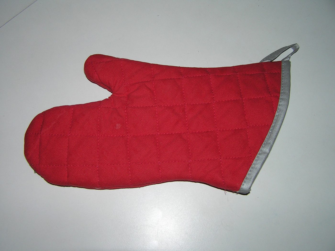 red quilted oven glove for handling hot trays and tins