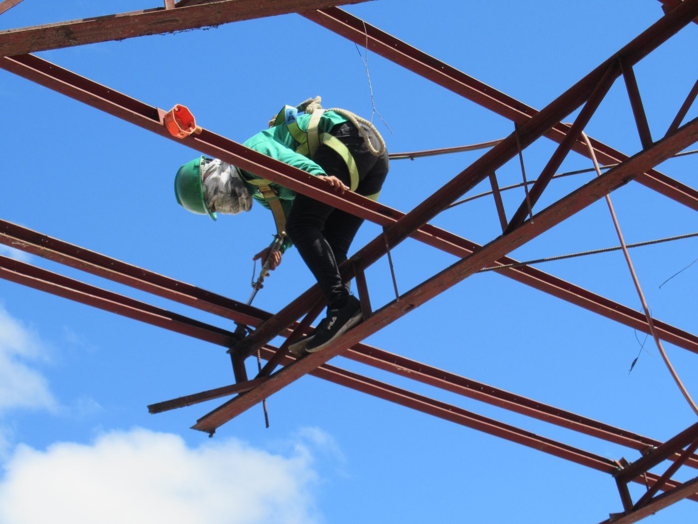 Worker wearing impact-resistant helmet on steel structure