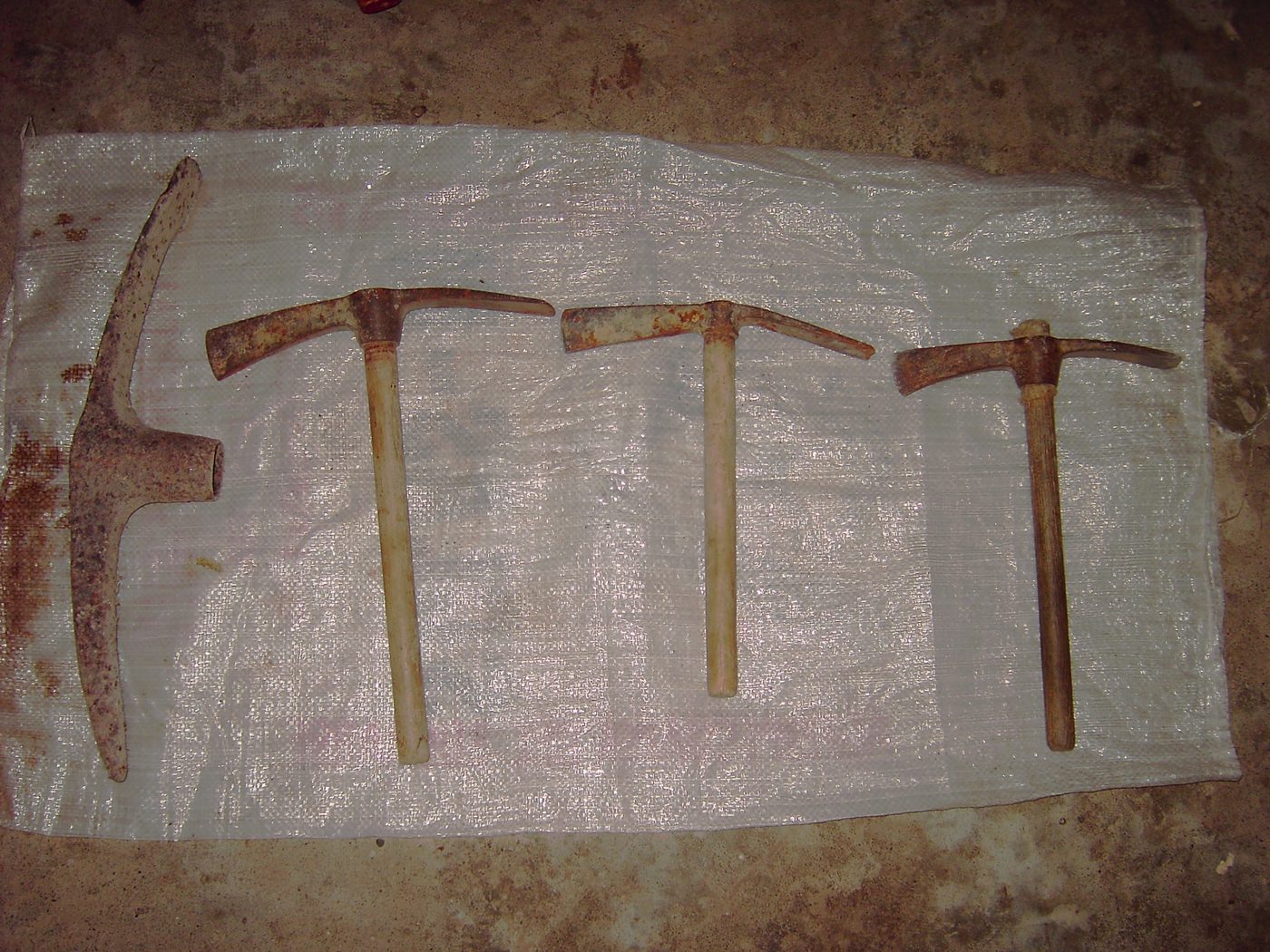 Four mattocks laid out on a white sheet