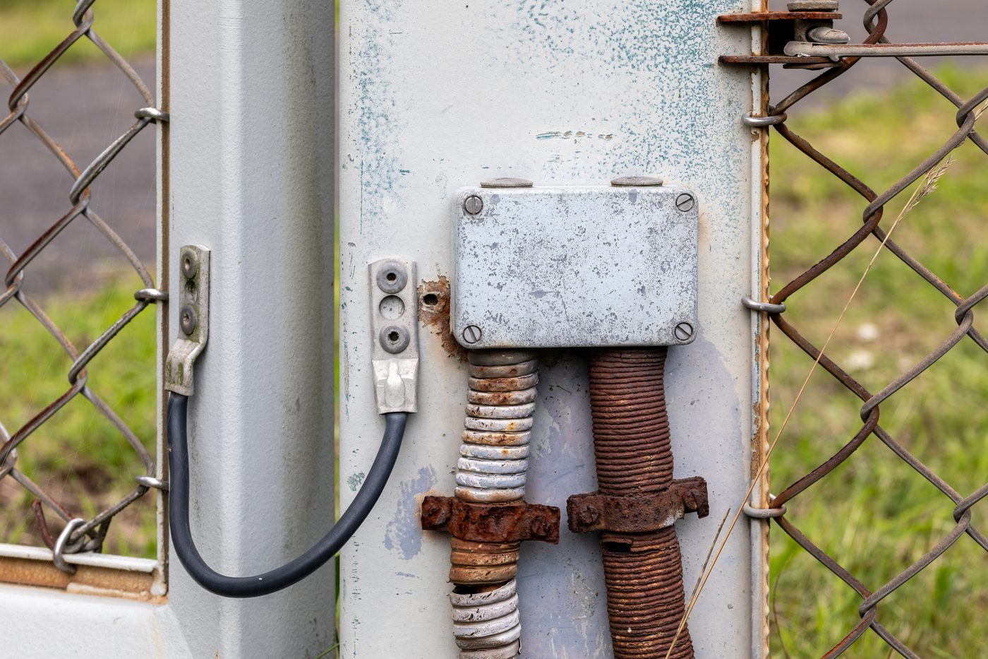 metallic electrical junction box on a fence post