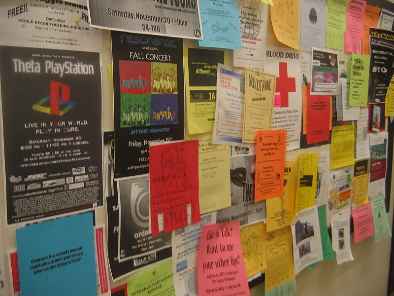 A notice board covered with various flyers