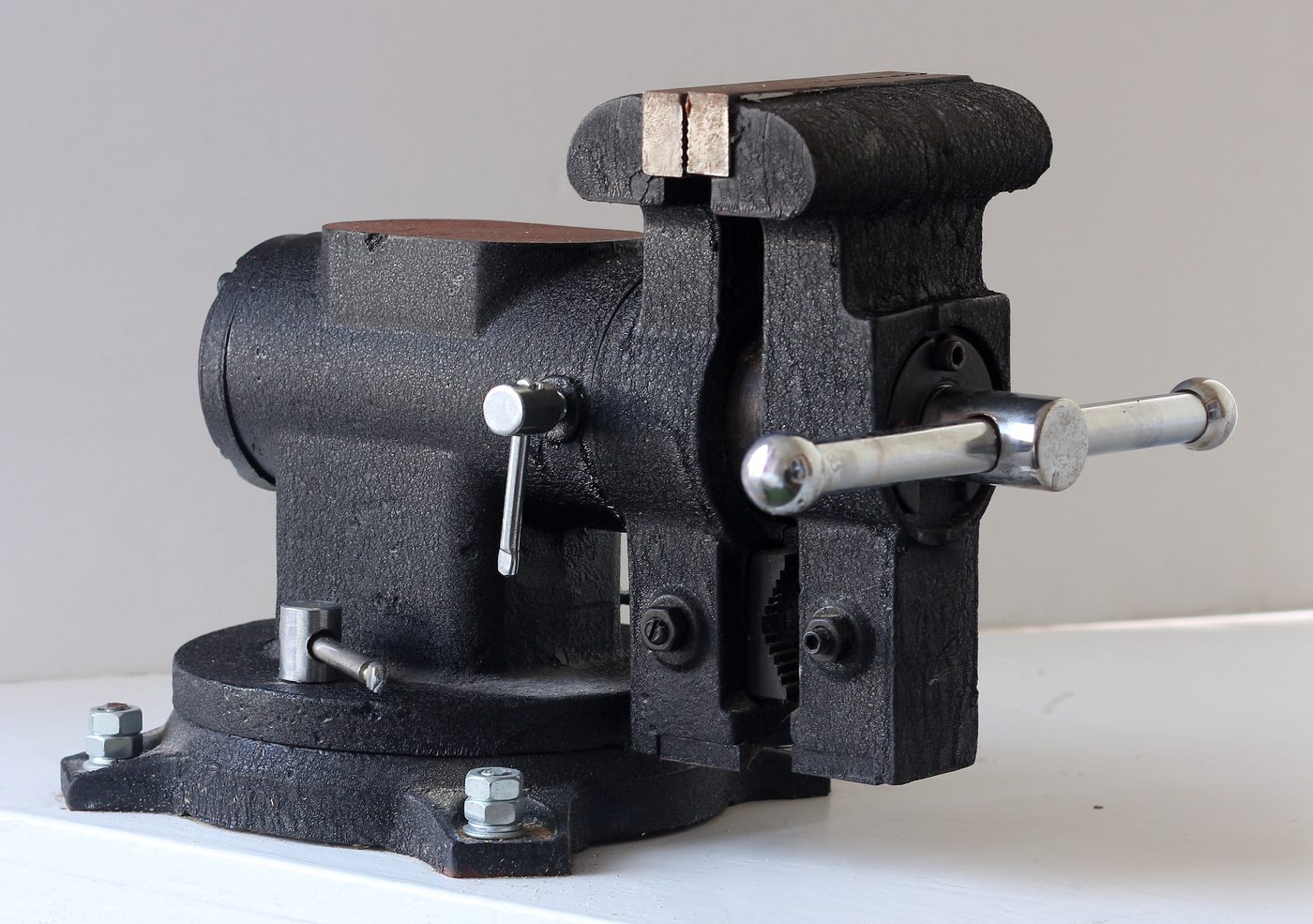 Black metal bench vice on white surface