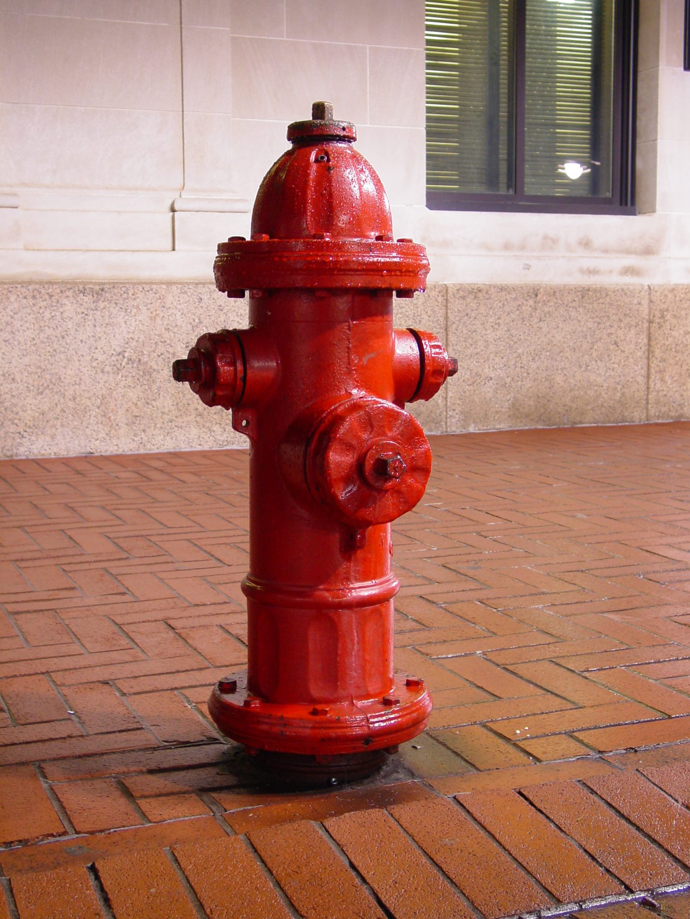 Red wet barrel fire hydrant on pavement