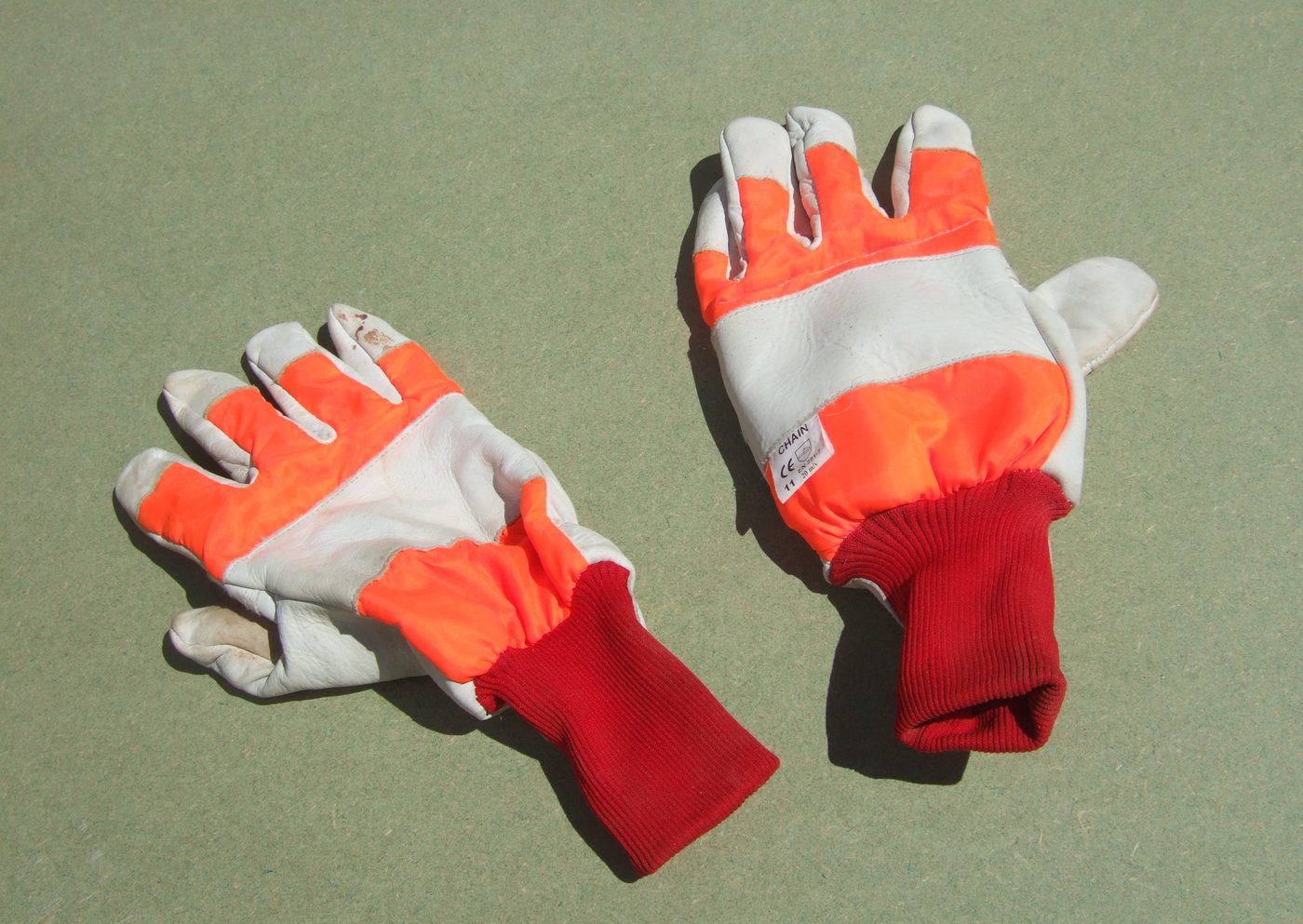 Pair of work gloves with orange and white colors